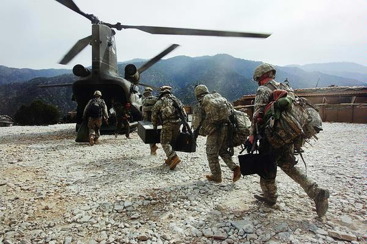 Tentara Amerika Serikat berlari ke helikopter angkut Chinook seusai memasok pasukan baru dan perbekalan ke Lembah Korengal, Afganistan, 27 Oktober. Tentara AS berada di Afganistan bagian dari 