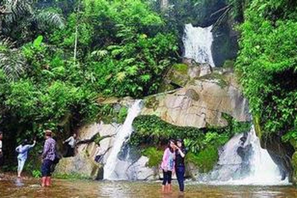 Pengunjung menikmati kesegaran air terjun di Taman Eden 100 di Kecamatan Lumban Julu, Kabupaten Toba Samosir, Sumatera Utara, Selasa (27/12/2011). Taman Eden 100 merupakan hutan tropis buatan yang menjadi tempat wisata sekaligus contoh pelestarian alam.