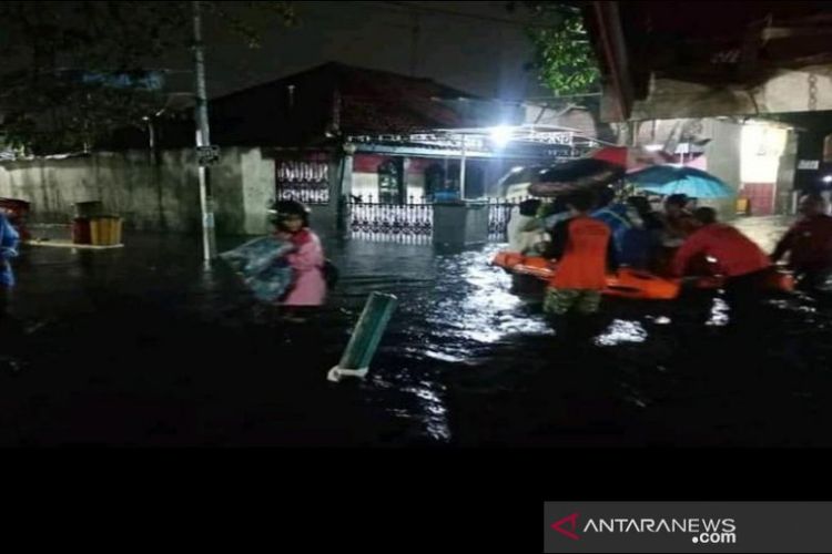 Petugas Badan Penanggulangan Bencana Daerah Kota Pekalongan sedang melakukan proses evakuasi para korban yang rumahnya dilanda banjir. 