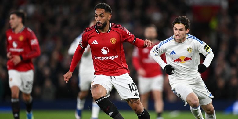 Matheus Cunha berlari dengan bola dalam pertandingan sepak bola Liga Inggris antara Manchester United vs Leeds United di Old Trafford di Manchester, barat laut Inggris, pada 13 April 2026. (Foto oleh Paul ELLIS / AFP)