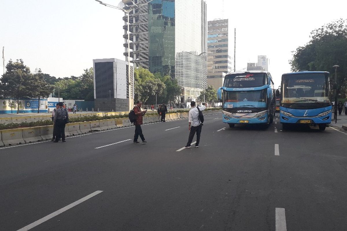 Pekerja kantoran yang dipulangkan dari kantornya berfoto-foto di tengah lengangnya Jalan MH Thamrin, Rabu (22/5/2019).