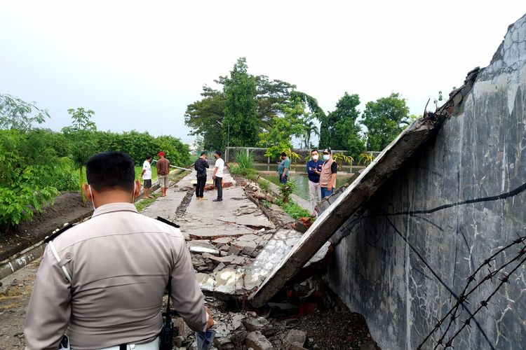 Seorang polisi berjaga di lokasi kejadian tembok roboh di Kota Blitar yang menewaskan seorang bocah laki-laki berusia 11 tahun, Sabtu sore (19/6/2021)