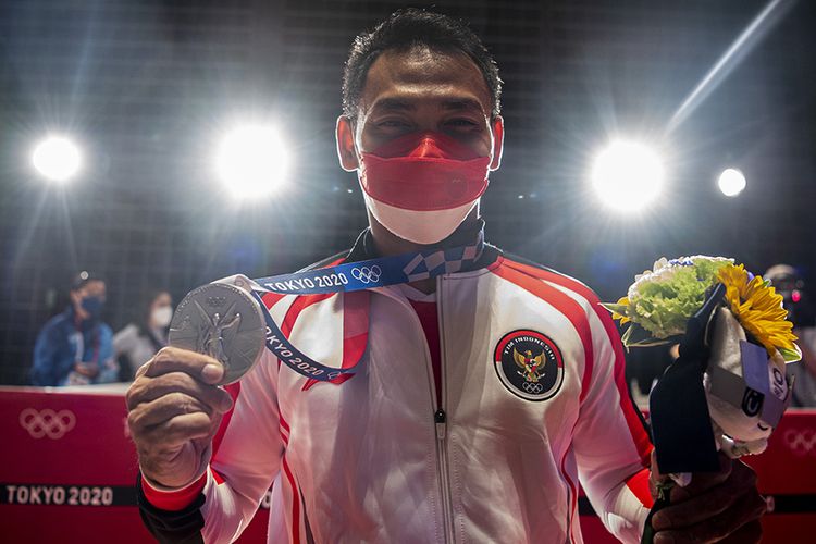 Lifter Indonesia Eko Yuli Irawan menunjukkan medali perak kelas 61 kg putra Grup A Olimpiade Tokyo 2020 di Tokyo International Forum, Tokyo, Jepang, Minggu (25/7/2021). Eko Yuli berhasil mempersembahkan medali perak dengan total angkatan 302 kg.