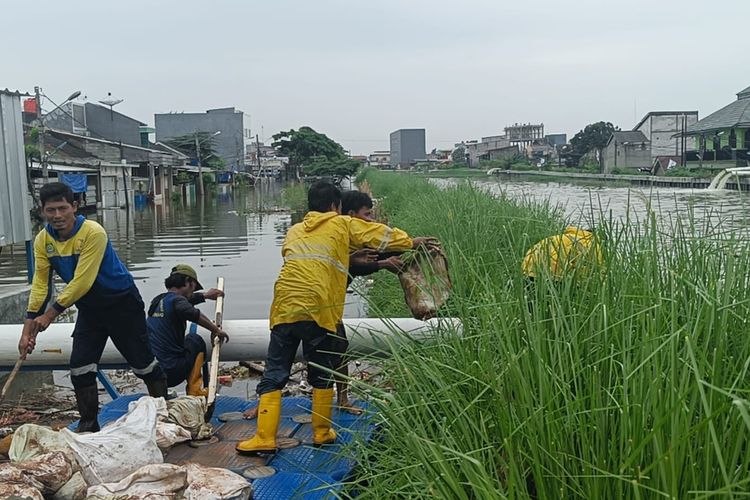 Untuk mengatasi banjir yang menggenangi rumah warga di Regency Periuk, Dinas PUPR Kota Tangerang telah mengerahkan sejumlah petugas untuk memperbaiki sementara tanggul jebol itu dengan kisdam, Rabu (15/3/2023)..