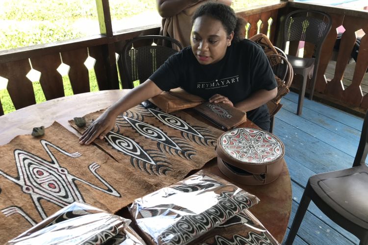 Serra Esterlin Ohee (24), pengusaha muda asal Pulai Asei Besar menunjukkan hasil kerajinan kulit kayu dari pohon Khombouw di Dermaga Pantai Khalkote, Jayapura, Papua pada Jumat (22/7/2022) siang. Serra yang juga merupakan Pegawai Negeri Sipil berstatus honerer membuat merek usahanya yakni Reymay Art.