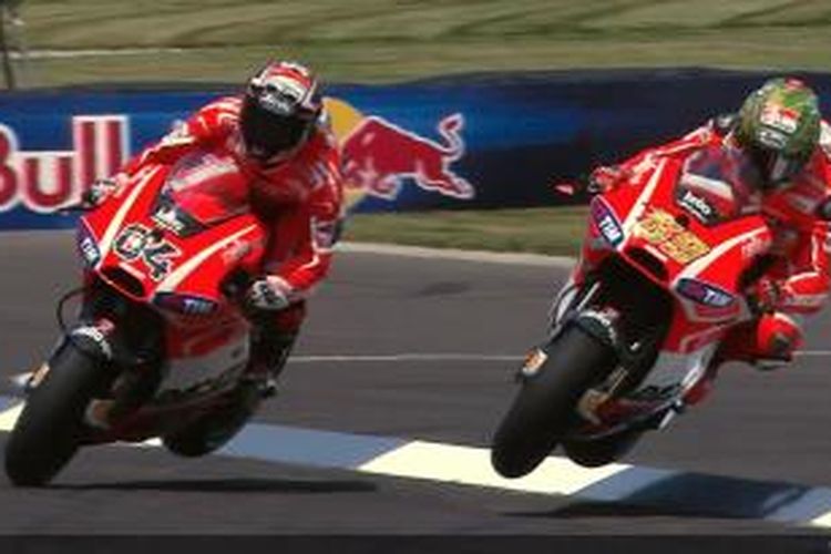 Dua pebalap Ducati, Nicky Hayden (kanan) dan Andrea Dovizioso, melewati trotoar dan keluar lintasan saat bersaing di tikungan terakhir Sirkuit Indianapolis Motor Speedway, pada balapan GP Indianapolis, Minggu (18/8/2013).