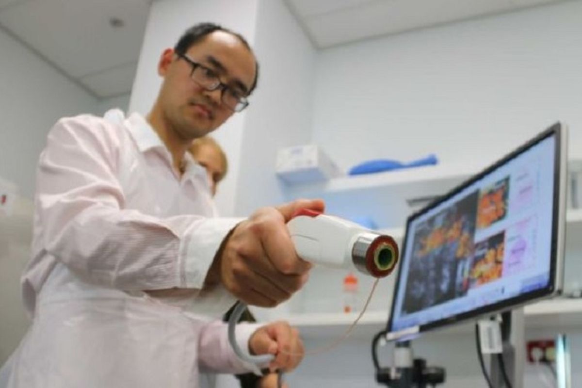 Peneliti Qi Fang dengan alat pemindai genggam yang dikembangkan di Perth.

