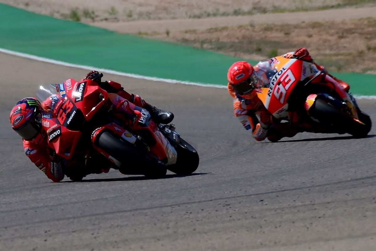Pebalap Francesco Bagnaia (Ducati) mengendarai motornya di depan pebalap Repsol Honda Marc Marquez (kanan) pada MotoGP Aragon di Sirkuit Motorland di Alcaniz pada 12 September 2021.