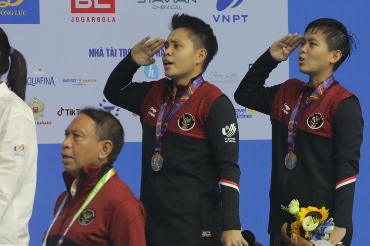 Pasangan ganda putri Indonesia Apriyani Rahayu/Siti Fadia Silva Ramadhanti menyanyikan Indonesia Raya dalam seremoni juara seusai meraih medali emas bulu tangkis SEA Games 2021.