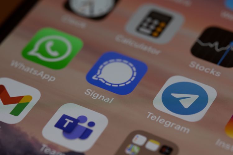 Ilustrasi aplikasi WhatsApp dan Telegram yang dipisahkan aplikasi Signal.