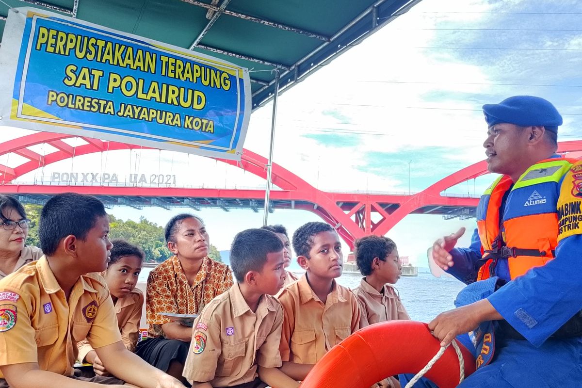 Aipda Imbron Kurniawan, Bhabinkamtibmas Kampung Enggros dari Polairud Polresta Jayapura Kota, saat memberikan edukasi kepada anak-anak di Perpustakaan Terapung milik Polresta Kota Jayapura, Kamis (14/8/2025).