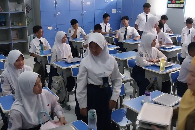 Pelajar SMPN 2 Tasikmalaya, Jawa Barat, sedang menyantap pembagian makan bergizi gratis dari pemerintah di ruang kelasnya pada Senin (6/1/2025) siang.