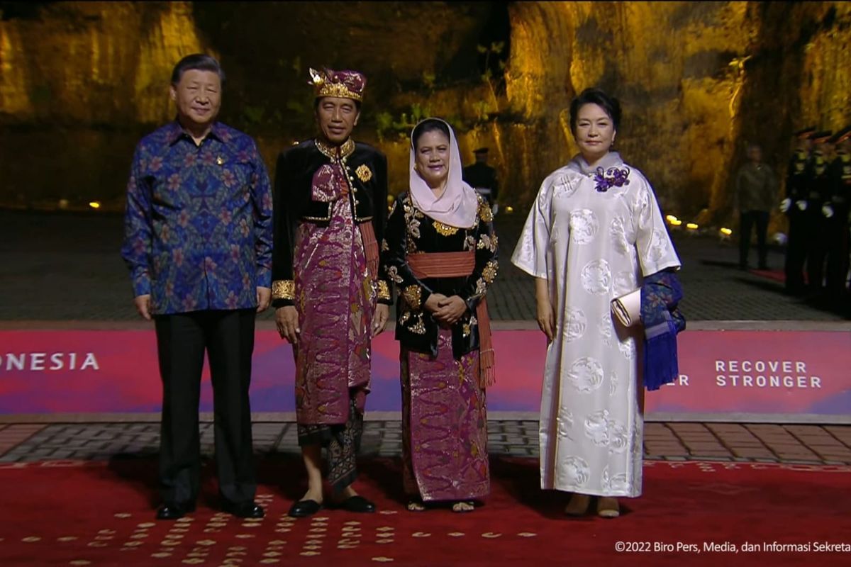 Presiden Joko Widodo (Jokowi) dan Ibu Iriana menyambut kedatangan Presiden China Xi Jinping yang memakai batik bernuansa biru gelap dengan motif bunga berwarna kuning saat jamuan makan malam KTT G20 di kawasan Garuda Wisnu Kencana (GWK), Badung, Bali, Selasa (15/11/2022). 