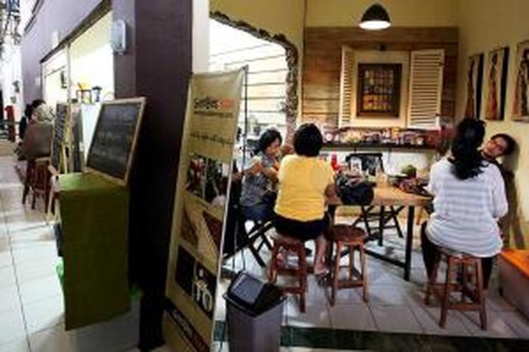 Pengunjung menikmati kopi di salah satu kios di Pasar Santa, Kebayoran Baru, Jakarta Selatan, Minggu (14/9/2014). Di pasar tradisional tersebut bermunculan restoran dan kafe layaknya di mal yang kini mulai ramai dikunjungi warga yang berwisata kuliner.