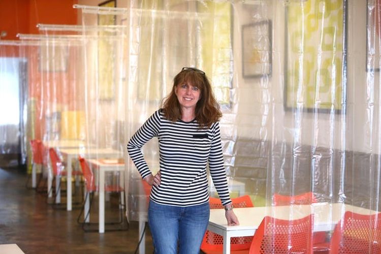 Kim Shapiro, co-owner of Twisted Citrus dengan gambar restorannya yang sudah diberi sekat antar pengunjung. 