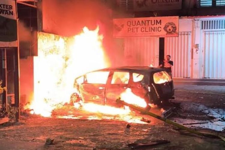 TERBAKAR - Mobil Honda Jazz ludes terbakar usai menabrak pohon dan lapak bensin eceran di Jalan Danau Bratan Kelurahan Sawojajar Kecamatan Kedungkandang Kota Malang, Rabu (16/7/2025). Akibat kejadian tersebut, pengemudi mobil mengalami luka bakar dan dievakuasi ke Rumah Sakit Saiful Anwar (RSSA).