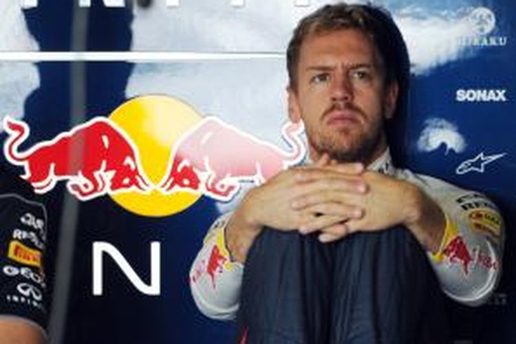 Pebalap Red Bull, Sebastian Vettel duduk di pit dan menonton monitor TV saat sesi latihan bebas pertama GP Jepang, di Sirkuit Suzuka, Jumat (11/10/2013). 