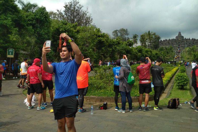Para pelari ber-swafoto pakai medali Bank Jateng Borobudur Marathon 2018 di depan candi Borobudur Magelang, Minggu (18/11/2018).