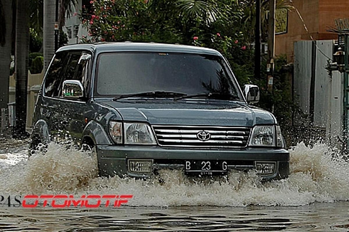 Mobil melintas di Perumahan Green Garden, Jakarta Barat yang terendam banjir, Rabu (4/4/2012)