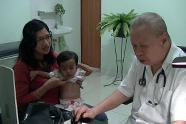 Dokter Lo saat memeriksa pasien di rumahnya, Sabtu (30/11/2013). 