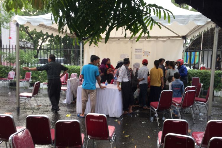 Antrean warga yang mengurus KTP elektronik masih nampak di kawasan Taman Mini Indonesia Indah, Jakarta Timur, Minggu (22/10/2017) sore. Layanan pengurusan KTP elektronik yang dibuka sejak hari Rabu (18/10/2017) ini diminati oleh warga dari Jakarta dan sekitarnya. 