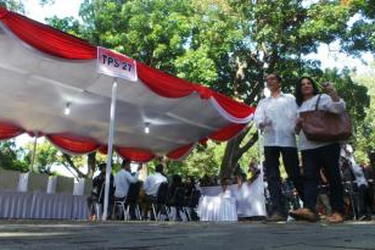 Gubernur Jakarta Joko Widodo dan sang istri Iriana menggunakan hak pilihnya di TPS 27, Menteng, Jakarta Pusat, Rabu (9/4/2014).