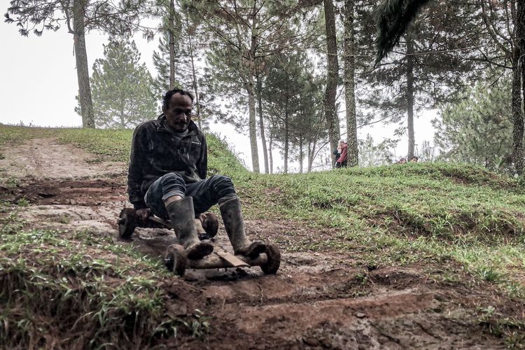 Seorang warga meluncur menggunakan Kadaplak di kaki Gunung Bukit Tunggul, Kampung Pasir Angling, Desa Suntenjaya, Kecamatan Lembang, Kabupaten Bandung Barat (KBB), Jawa Barat, Senin (26/2/2024).