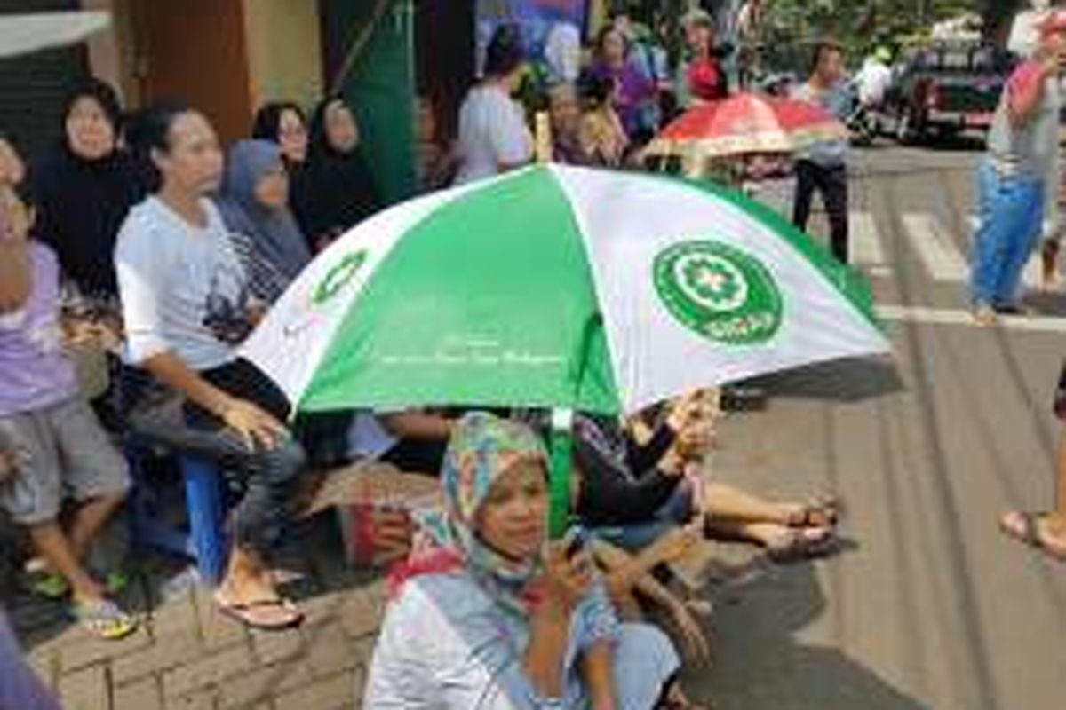 Warga Jalan Lauser mendengarkan pengunguman penundaan SP-2 di depan pintu masuk permukimannya di RT 08/08, Gunung, Kebayoran Baru, Jakarta Selatan, Senin (9/5/2016).