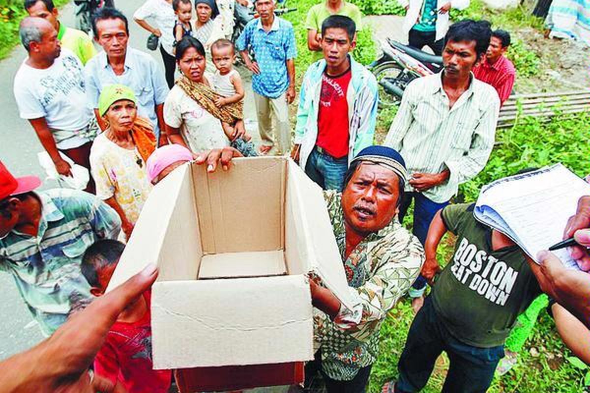 Penduduk Desa Lempur, Nagari Padang Alai, Kecamatan V Koto Timur, Padang Pariaman, Sumatera Barat, antre mendapatkan bahan makanan, Minggu (4/10). Di daerah ini bantuan masih minim.