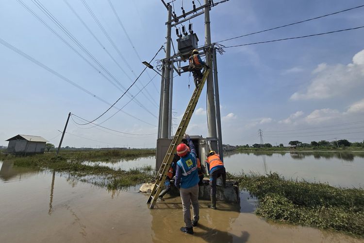 Petugas PLN sedang melakukan pengecekan gardu di Tambun, Bekasi pascabanjir.
