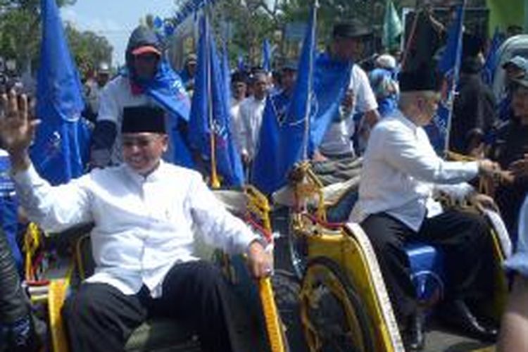 Pasangan Calon Bupati dan Wakil Bupati Malang, Rendra-Kresna (kiri-kanan) saat diarak naik becak usai daftar ke KPU menuju Stadion Kanjuruhan, untuk deklarasi. Deklarasi dihadiri belasan ribu pendukungnya. Senin (27/7/2015).