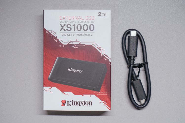 Kotak kemasan SSD eksternal Kingston XS1000. Kabel USB C to USB C di kanan diberikan secara terpisah kepada KompasTekno dan tidak termasuk dalam paket penjualan. 