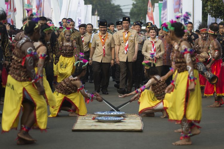 Presiden Joko Widodo (tengah) berjalan bersama Ibu Negara Iriana Joko Widodo (kanan) dan  Ketua Kwartir Nasional Gerakan Pramuka Adhyaksa Dault (kiri) mengikuti prosesi Raimuna Nasional XI yang bertepatan dengan peringatan ulang tahun Pramuka ke-56 di, Bumi Perkemahan Cibubur, Jakarta, Senin (14/8/2017). Sebanyak 15 ribu Pramuka Penegak dan Pandega dari 34 provinsi dan 514 kota/kabupaten serta pramuka luar negeri mengikuti kegiatan bertajuk Pramuka untuk Masa Depan Indonesia: kreatif, inovatif, berkarakter. ANTARA FOTO/Rosa Panggabean/aww/17.