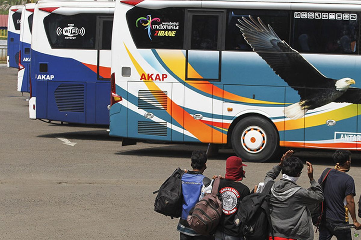 Sejumlah calon penumpang bersiap naik bus di area Terminal Jatijajar, Depok, Jawa Barat, Kamis (23/4/2020). Pemerintah memutuskan kebijakan larangan mudik Lebaran 2020 bagi masyarakat mulai berlaku Jumat (24/4) guna memutus mata rantai penyebaran COVID-19.