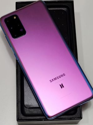 Galaxy S20 BTS Edition jika dilihat dari belakang. Ada logo BTS di bagian bawah serta ikon hati di dalam modul kamera. Cangkangnya sendiri tampak berwarna ungu, seirama dengan ungkapan ikonik I Purple You.