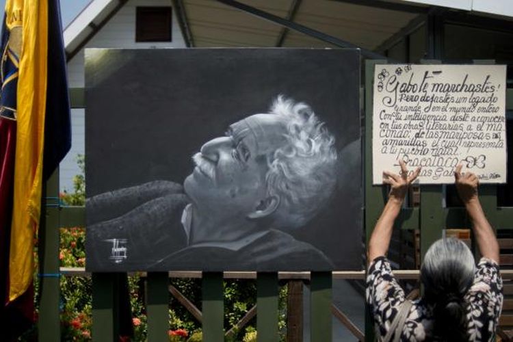 Seorang perempuan, Jumat (18/4/2014), menempelkan pengumuman di samping gambar wajah Gabriel Garcia Marquez, penulis dan penerima Nobel Sastra 1982, yang meninggal pada Kamis (17/4/2014) dalam usia 87 tahun.