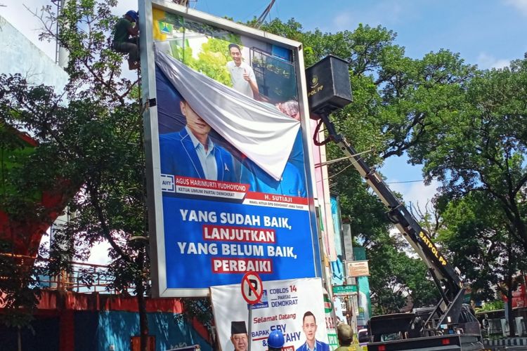 Petugas Satpol PP Kota Malang menertibkan Alat Peraga Kampanye (APK) di sekitar Stadion Gajayana, Kota Malang dengan menerjunkan kendaraan tangga hidrolik pada Minggu (11/2/2024). 
