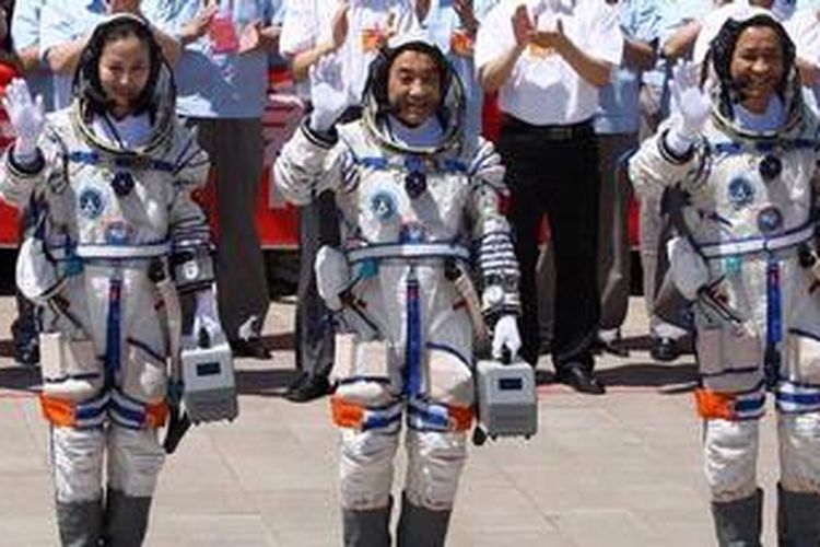 Tiga astronot China (kiri ke kanan), Wang Yaping, Zhang Xiaoguang, dan komandan misi Nie Haisheng melambai ke arah massa sebelum memasuki kapsul Shenzou-10 yang akan membawa mereka ke orbit Bumi. Shenzou-10 berhasil diluncurkan dari gurun Gobi, Selasa (11/6/2013).