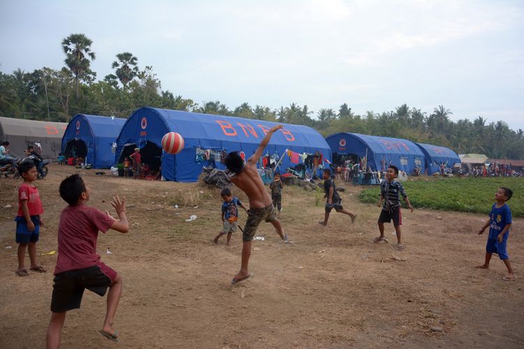 Sejumlah anak pengungsi letusan Gunung Agung bermain bola di posko pengungsian Desa Les, Kabupaten Buleleng, Bali, Minggu (24/9). Jumlah pengungsi Gunung Agung, Kabupaten Karangasem, 2.423 jiwa yang tersebar di 10 titik di Kabupaten Buleleng dan jumlah tersebut terus bertambah karena masih ada beberapa warga yang bertahan di rumahnya walaupun status gunung sudah pada level awas. ANTARA FOTO/Wira Suryantala/ama/17.