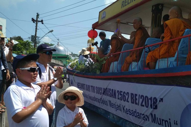 Umat Buddha menanti percikan air berkah dari para Biksu dalam kirab Waisak dari Candi Mendut ke Candi Borobudur, Kabupaten Magelang, Jawa Tengah, Selasa (29/5/2018).