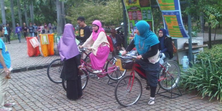 Pengunjung tengah mencoba sepeda yang bisa mencharge telepon genggam di Festival taman di Taman Cattleya, Tomang, Jakarta Barat, Sabtu (19/10/2013).