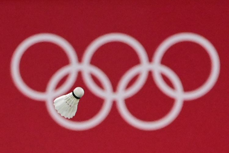 A shuttlecock flies in front of the Olympic rings logo during the women's singles badminton round of 16 match between Japan's Akane Yamaguchi and South Korea's Kim Ga-eun during the Tokyo 2020 Olympic Games at the Musashino Forest Sports Plaza in Tokyo on July 29, 2021. (Photo by Pedro PARDO / AFP)