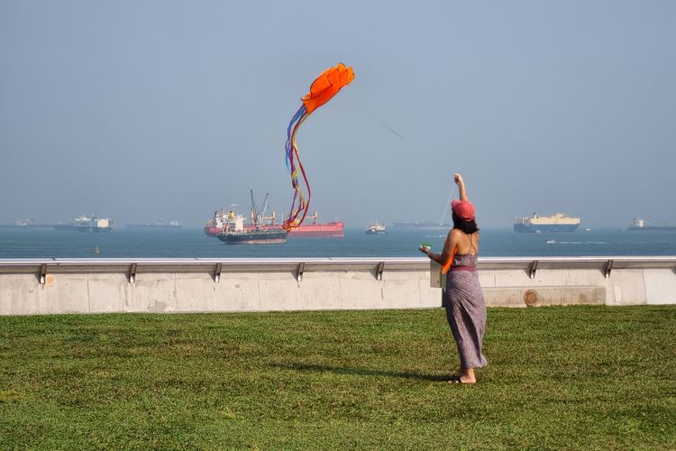 Seorang pengunjung bermain layangan di rooftop Marina Barrage, Singapura, Jumat (6/10/2023).