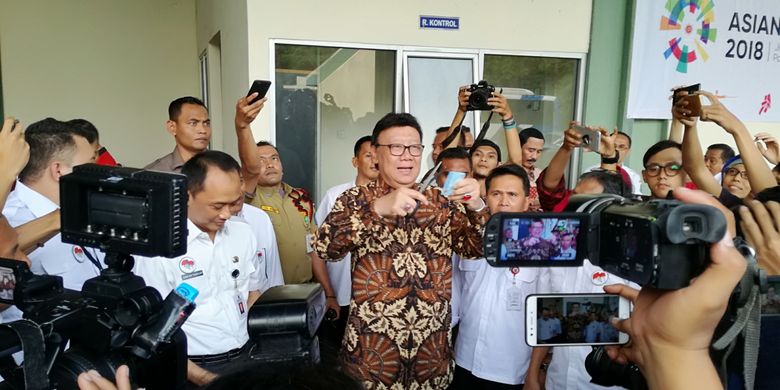 Menteri Dalam Negeri Tjahjo Kumolo memotong ujung kanan atas salah satu e-KTP yang rusak di gudang penyimpanan barang inventarisasi Kemendagri, Bogor, Jawa Barat, Rabu (30/5/2018)