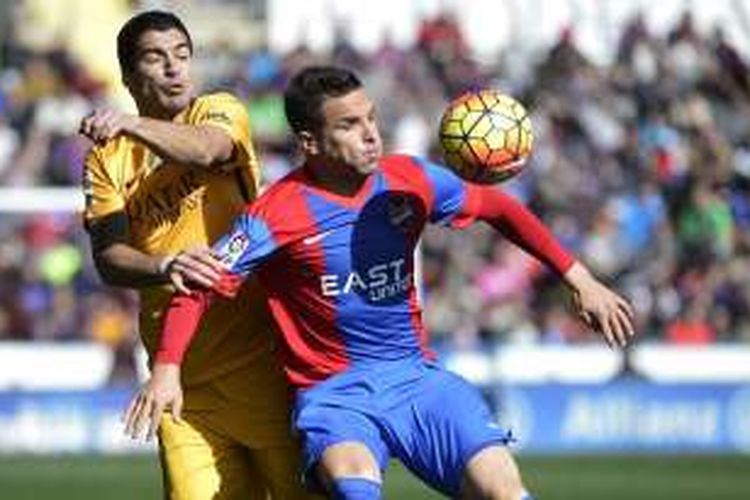 Penyerang Barcelona, Luis Suarez (kiri), berupaya merebut bola dari bek Levante, Tono Garcia, pada laga lanjutan La Liga di Estadio Ciudad de Valencia, Minggu (7/2/2016).