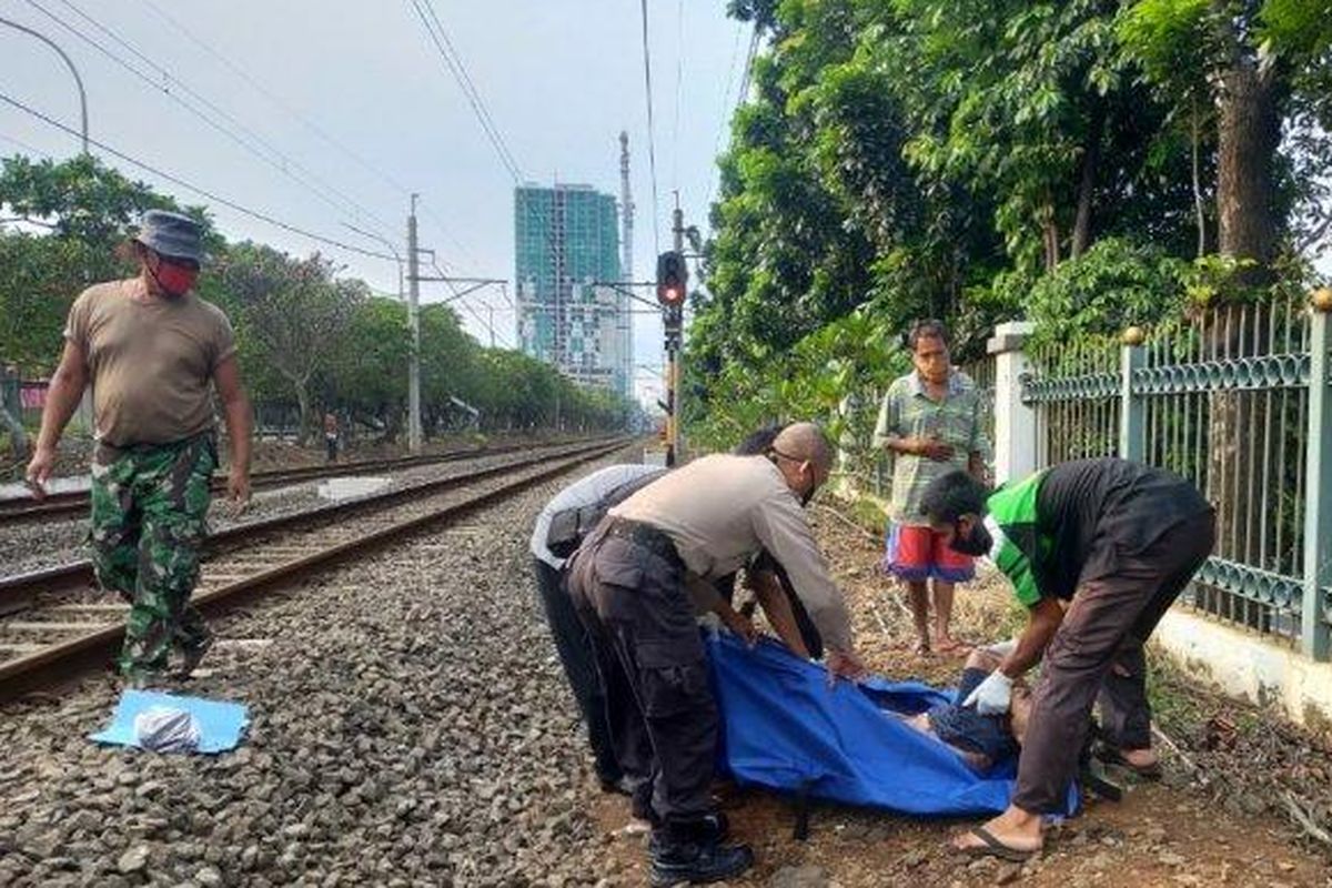 Petugas mengevakuasi jenazah pria yang tewas tertabrak kereta di kawasan Tanjung Barat, Jakarta Selatan, Jumat (22/5/2020)