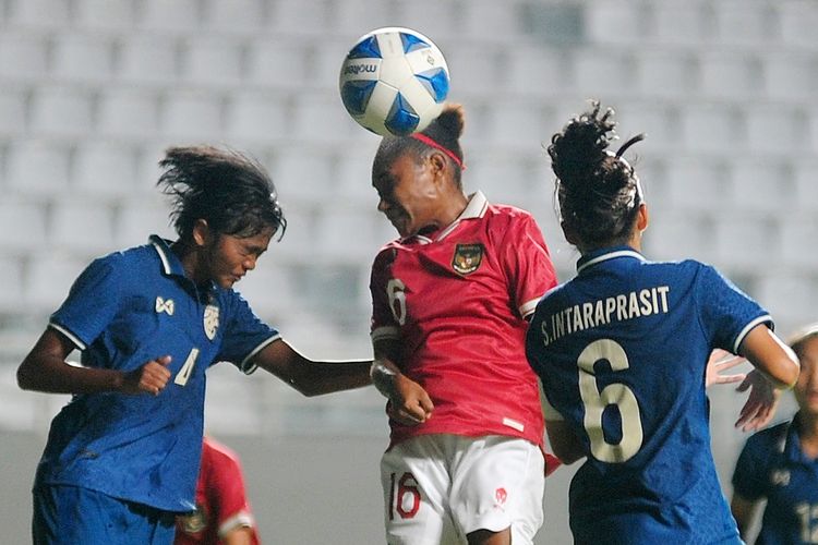 Pesepak bola Tim Nasional wanita U18 Indonesia Ina Paulanda Wetipo (tengah) berebut bola di udara dengan dua Pesepakbola Tim Nasional Wanita U18 Thailand Parichat Thongrong (kiri) dan Suprapon Intraprasit (kanan)  dalam pertandingan penyisihan Grup A Piala AFF Wanita U18 2022 di Stadion Gelora Sriwijaya Jakabaring Palembang, Sumatera Selatan, Kamis (28/7/2022). Indonesia gagal melaju ke semifinal usai dikalahkan Thailand dengan skor 3-0. ANTARA FOTO/Feny Selly/YU