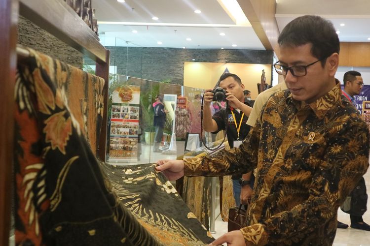 Menteri Pariwisata dan Ekonomi Kreatif, Wishnutama Kusubandio melihat batik yang dipamerkan di acara Indonesian Tourism Summit 2019 yang berlangsung di Upperroom Jakarta, Selasa (17/12/2019).
