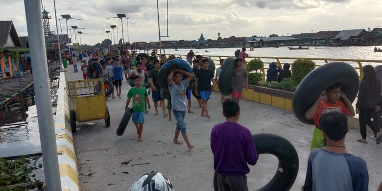 Setelah puas menghanyutkan diri atau bekanjur banyu mengikuti arus sungai hingga ke hilir, warga kembali ke hulu dengan berjalan kaki, Minggu (26/7/2020). Bekanjur banyu adalah kebiasaan masyarakat tepian Sungai Arut, Kalimantan Tengah, saat air sungai meninggi.  