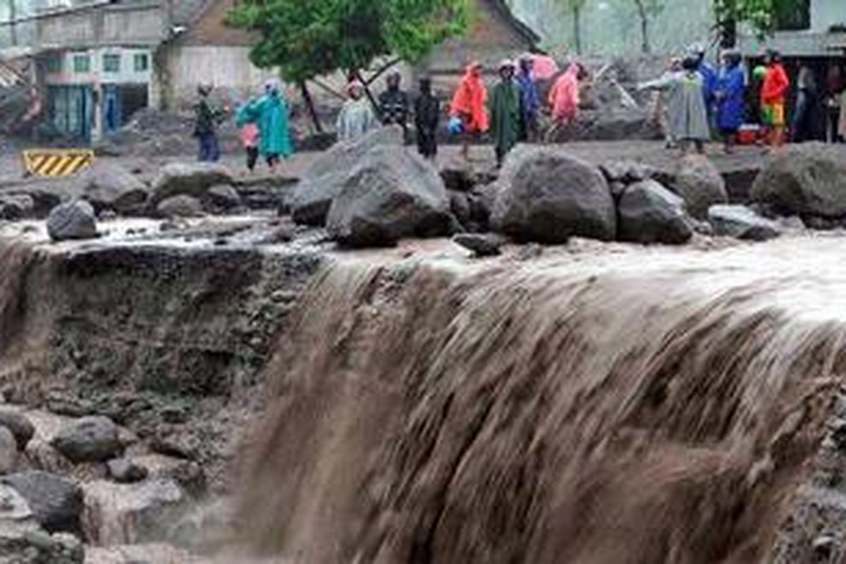 Lebih dari setengah lebar badan jalan raya Yogyakarta-Magelang di Desa Jumoyo, Kecamatan Salam, Kabupaten Magelang, Jawa Tengah, tergerus oleh banjir lahar dingin, Minggu (23/1/2011). Badan jalan yang semula bisa digunakan empat lajur tersebut saat ini hanya tinggal tersisa satu lajur.